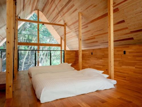 una cama en una habitación con una ventana grande en Retreat Villa iki, en Kō