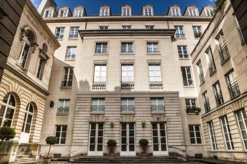 a large stone building with potted plants in front of it at Assia & Nathalie - Luxury B&B MARAIS in Paris
