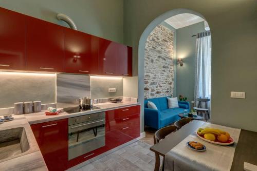 a kitchen with red cabinets and a blue couch in a room at Nancy's Timeless Elegance in Ermoupoli