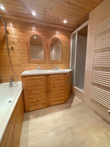 La salle de bains est pourvue d'une baignoire, de 2 lavabos et d'une baignoire. dans l'établissement Villa La Dune aux Loups, à Saint-Jean-de-Monts