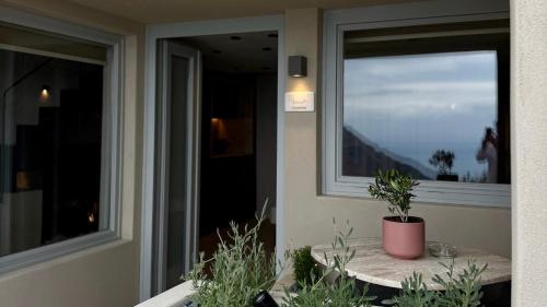 a balcony with a table with a potted plant on it at Agnadema Apartments in Firostefani