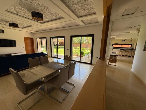a living room with a dining room table and chairs at Villa Denalya in Marrakech