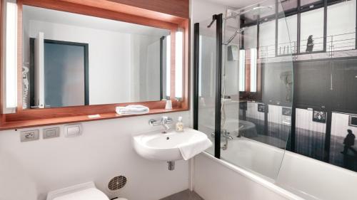 a bathroom with a sink and a shower and a mirror at Campanile NATURE - Dreux in Dreux