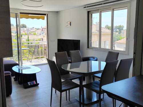 une salle à manger avec une table et des chaises et une fenêtre dans l'établissement Pointe Rouge near beach & marina, à Marseille