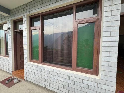 マナリにあるPeaceful Village Stayの山が映る家の窓