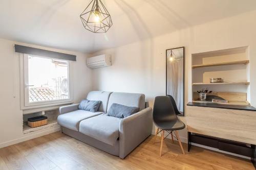 un salon avec un canapé et une table dans l'établissement Nice - Studette confort sur les toits au cœur du Vieux Nice, à Nice