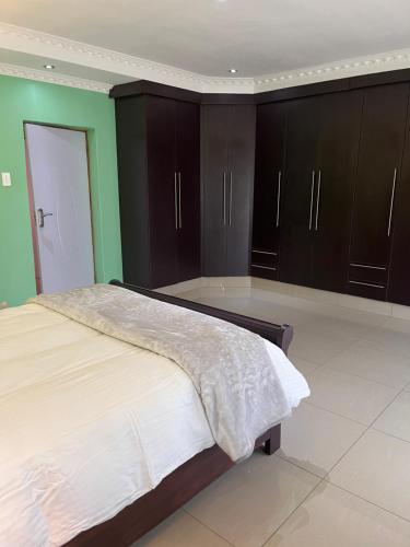 a bedroom with a large bed and brown cabinets at The Serene Gift in Mbabane