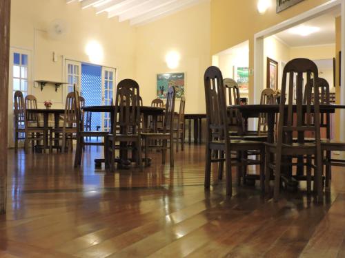 a dining room with wooden chairs and a table at Pousada D'amoras in Conservatória