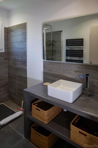 une salle de bain avec un lavabo et un miroir dans l'établissement Maison avec piscine à Maussane les Alpilles, à Maussane-les-Alpilles