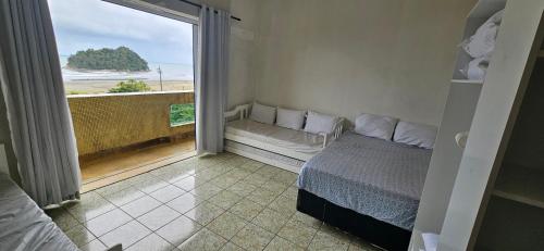 een slaapkamer met een bed en een groot raam bij Vista incrível para o mar! in Santos