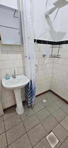 een badkamer met een wastafel en een douche bij Vista incrível para o mar! in Santos