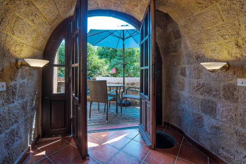 an open door to a patio with an umbrella at S.Nikolis' Historic Boutique Hotel in Rhodes Town