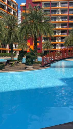 a large blue swimming pool in front of a building at Condo with sunset view MAIKHAO in Ban Mai Salae