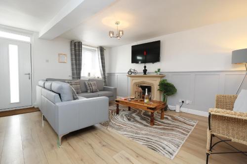 a living room with a couch and a fireplace at Cottage nr BikeParkWales/Brecon Beacons/PenYFan in Merthyr Tydfil