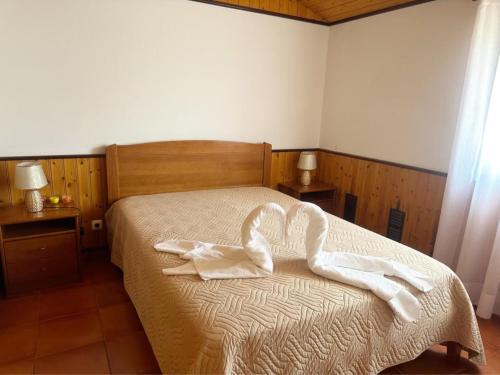 a bedroom with a bed with two towels on it at Casa Campo e Praia in Rogil