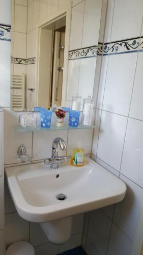 a bathroom with a white sink and a mirror at Ferienwohnungen Angela - Ruhe, Komfort und Erholung im Grünen in Bad Marienberg
