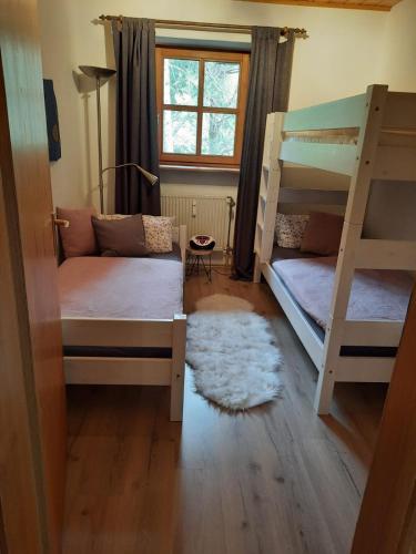 a bedroom with two bunk beds and a rug at Ferienwohnung AusZeit in Hauzenberg