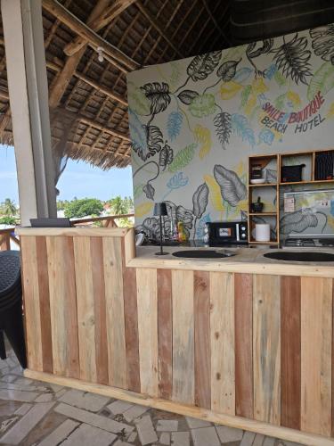 a restaurant with a wooden counter and a wall at Smile Boutique Beach hotel in Nungwi