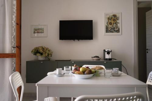 a white table with a bowl of fruit on it at Casa Marisa Design by the Sea in Torre Saracena