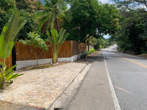 an empty road with a wooden fence and trees at Cocobeach Palomino in Palomino