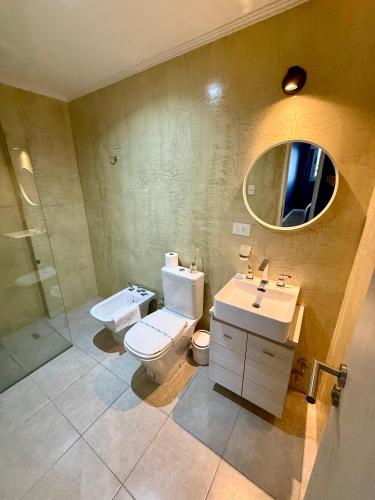 a bathroom with a toilet and a sink and a mirror at Departamento con Vista al Río in Posadas