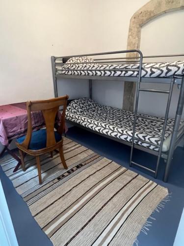 a room with two bunk beds and a chair at Belle maison Centre Sérignan in Sérignan