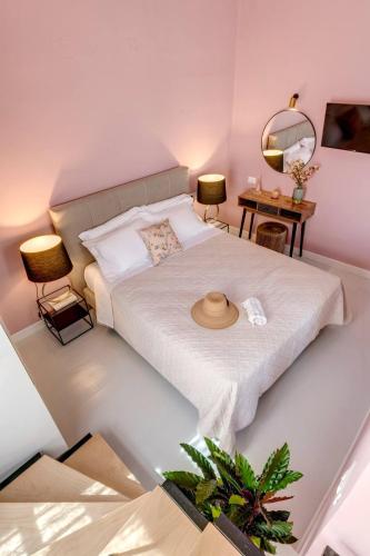a bedroom with a bed with a hat on it at Nancy's Timeless Elegance in Ermoupoli