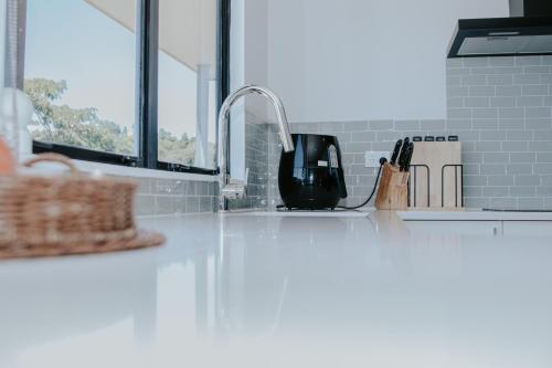 a kitchen counter with a sink and a mixer at Views at Welcome Bay Heights in Tauranga