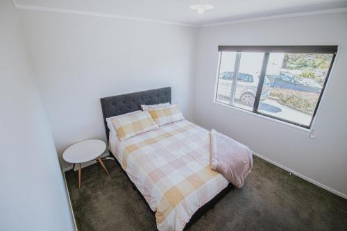 a bedroom with a bed and a window at Views at Welcome Bay Heights in Tauranga