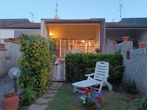 a white chair sitting in front of a house at La Casetta Vicino al Mare in San Vincenzo