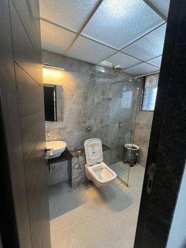 a bathroom with a toilet and a sink at Luxurious 3bhk Apartments in Pune