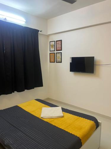 a bedroom with a bed with a yellow blanket at Luxurious 3bhk Apartments in Pune