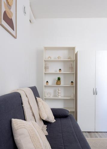 une chambre avec un canapé bleu avec des oreillers dans l'établissement Le Skandi Centre ville, à Reims