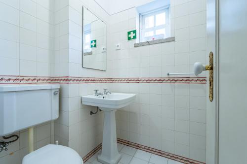 ein weißes Badezimmer mit Waschbecken und Spiegel in der Unterkunft Casa das Pintoras Garden and Pool in Vila Praia de Âncora