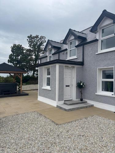 a house with a front door and a patio at Rose Cottage at Hilltop Hideaway in Barnesmore