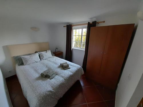 a bedroom with a bed with two shoes on it at casa de ferias in Algoz
