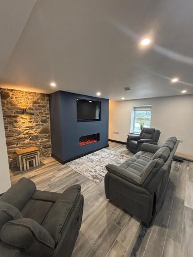 a living room with two couches and a fireplace at Rose Cottage at Hilltop Hideaway in Barnesmore