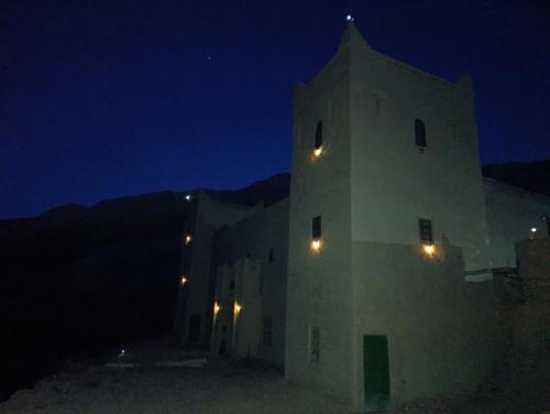 a white building with lights on it at night at KASBAH Atlas-Aberdouz in Aït Hattab