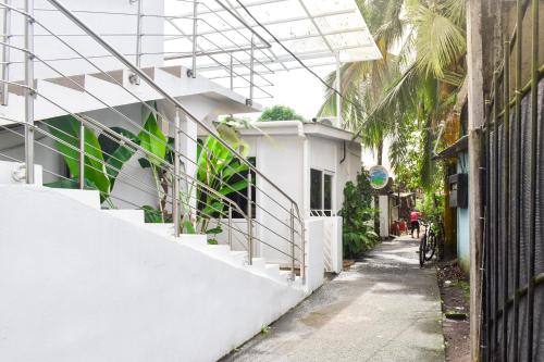 a small alley with a white building and a person on a bike at Hotel Serendipity in Tortuguero