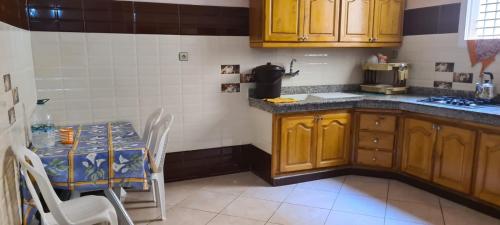 萨伊迪耶Appartement的厨房配有木制橱柜和桌椅