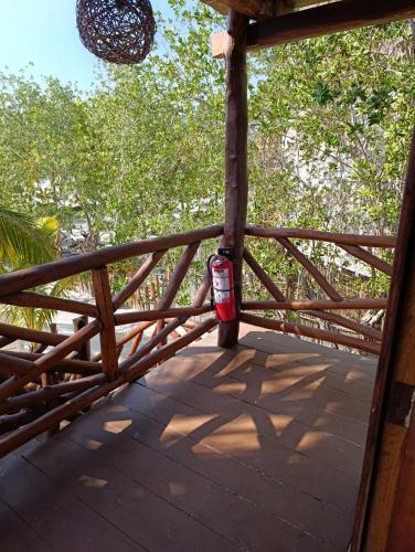 a wooden railing on a porch with trees at Hotelito Crismi in Holbox Island