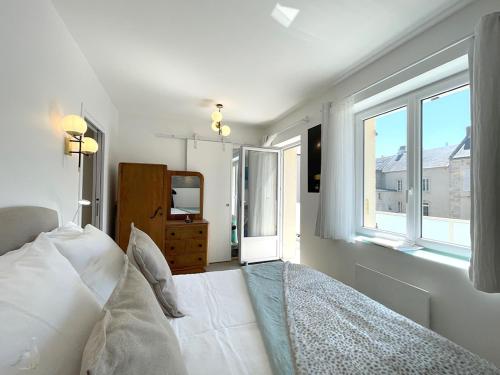 une chambre avec un lit blanc et une fenêtre dans l'établissement Fenêtre sur Mer I CAP MER, à Port-en-Bessin-Huppain