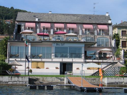 a building on the water with a dock in front at Hotel Bel Sit in Meina