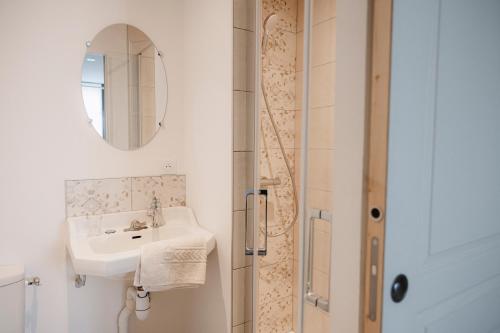 a white bathroom with a sink and a shower at Sancerre centre, Appartement duplex et ou Chambre indépendante, modulable in Sancerre