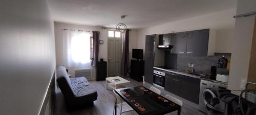 a small apartment with a kitchen and a living room at Studio meublé centre ville- gare Villers Cotterets in Villers-Cotterêts