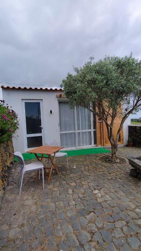 a picnic table and bench in front of a house at Basalto Negro AL in Angra do Heroísmo