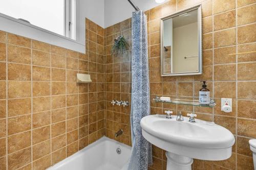 a bathroom with a sink and a mirror and a tub at #Urban Elegance 3BR With Parking Near UC BART & Downtown in Berkeley