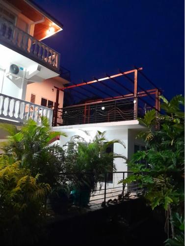 a white building with a balcony at night at T2 Villa Moana Nui in Punaauia