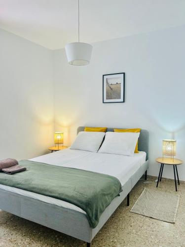 a bedroom with a large white bed with two tables at Médano Beach Blue in El Médano