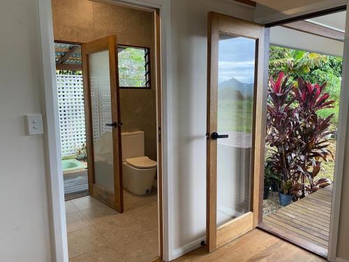 MyocumにあるThe Saddle Road Farmhouseのトイレとガラスのドアが付いたバスルーム